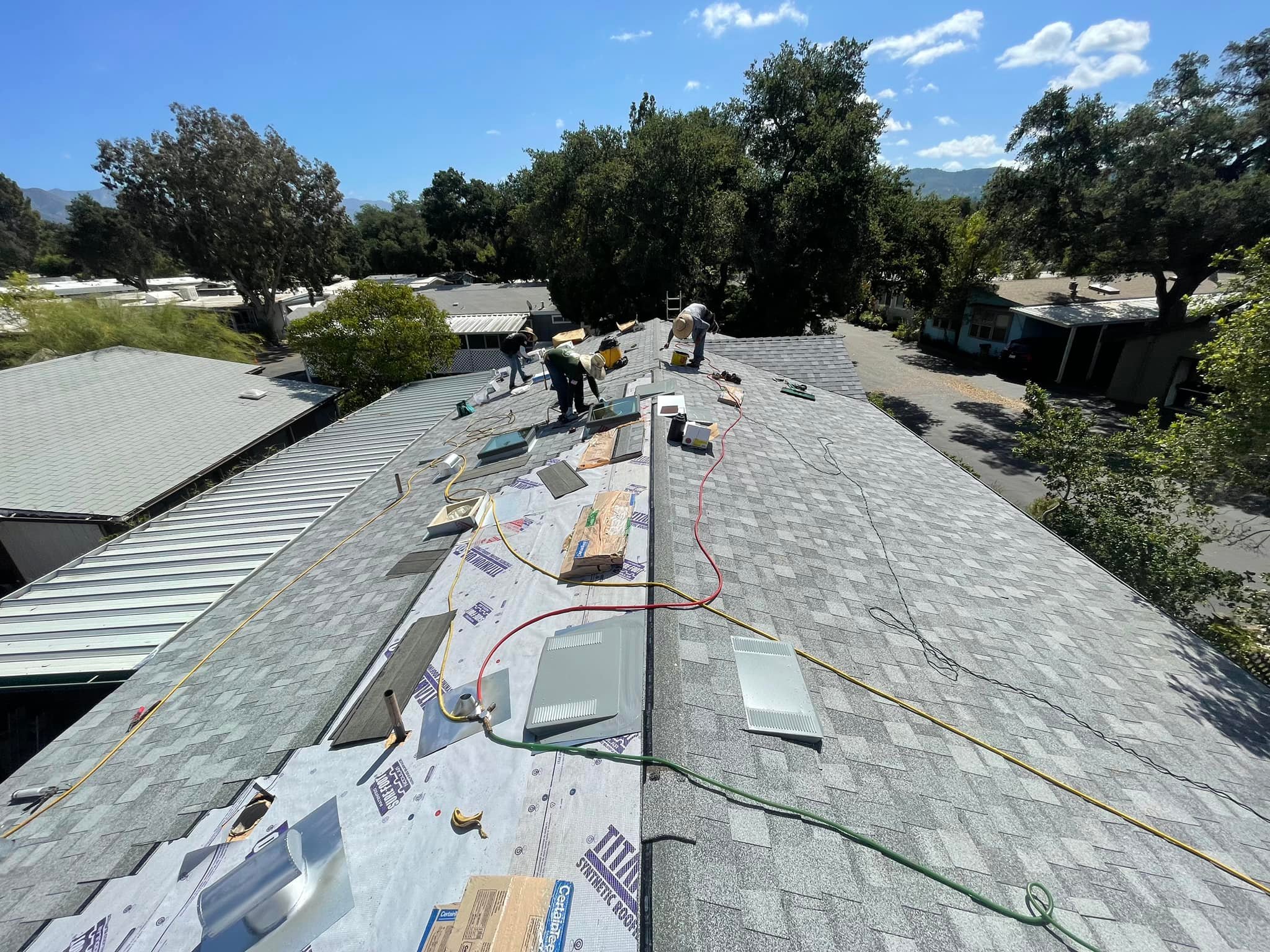roofing contractors installing shingle roof after homeowners asking how much does it cost to replace a shingle roof